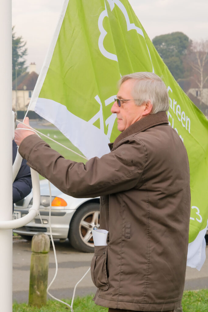 Steve Bridger raising the Green Award flag on the new flagpole